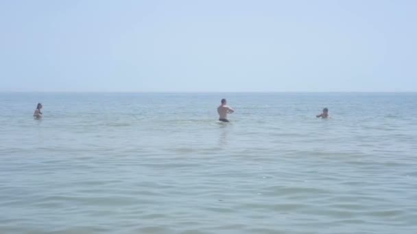 Jongens Baden in de zee en het spelen met een bal — Stockvideo