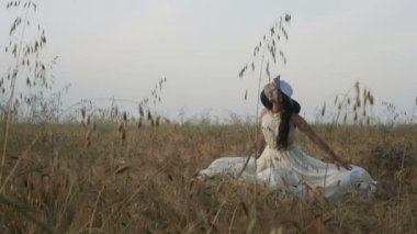 Kız esmer beyaz elbise ve şapka buğday alanında