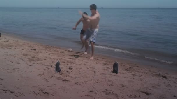 Dos chicos jugando mini fútbol en la playa en la playa — Vídeos de Stock
