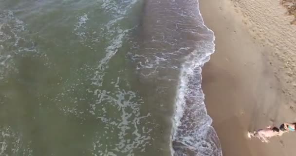 Утренняя пробежка девушка и парень вдоль линии серфинга морского пляжа летом — стоковое видео