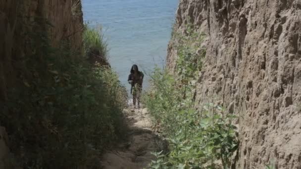 Meisje gaat naar beneden naar het strand op een zanderige oever — Stockvideo