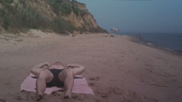 Ejercicio de hombre en la playa del mar en el soleado día de verano — Vídeo de stock