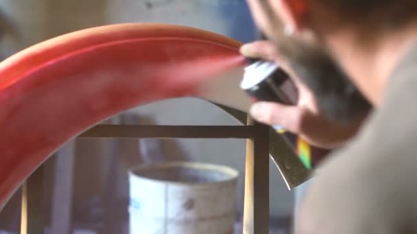 Homem com tatuagens colorir os detalhes da moto na garagem — Vídeo de Stock