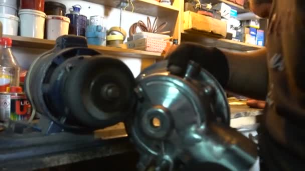 磨削摩托车部件在车库里的男人 — 图库视频影像