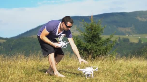 Joven usando dron en las montañas — Vídeos de Stock