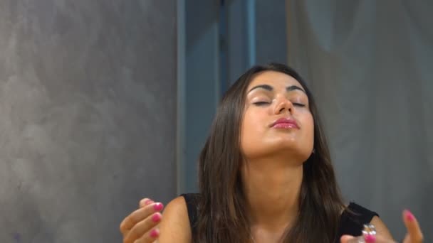 Дівчина бризкає парфуми в декольте і шиї — стокове відео