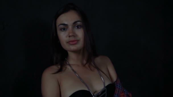Mädchen Brünette in rot kariertem Hemd und Jeanshose auf schwarzem Hintergrund — Stockvideo