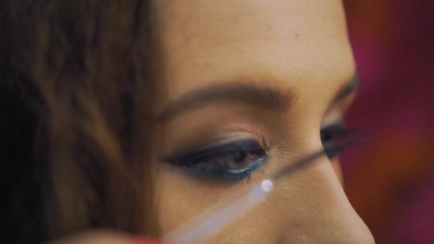 Girl puts false eyelashes on the eye with tweezers — Stock Video