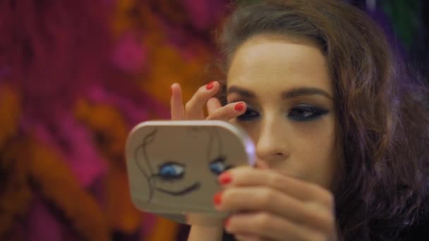 Vacker tjej med makeup applicerar lösögonfransar framför spegeln — Stockvideo