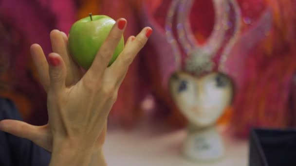Gadis cantik muda memegang dan memutar apel hijau di tangannya — Stok Video