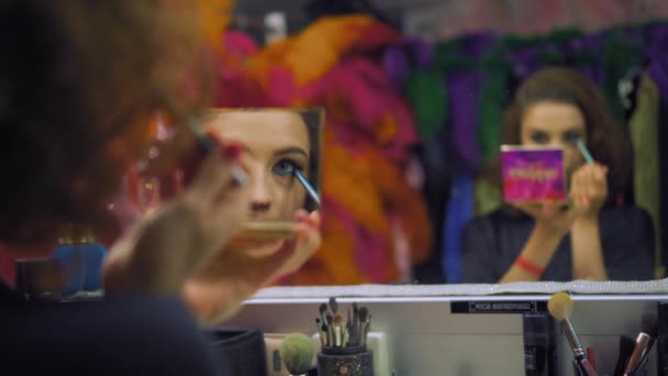 Menina coloca em maquiagem com delineador na frente do espelho — Vídeo de Stock