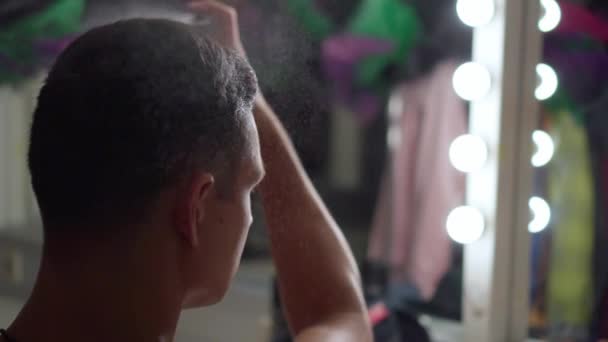 Acteur homme met vernis spray sur les cheveux devant le miroir dans le vestiaire coiffure — Video