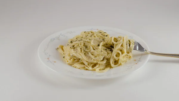  alfredo spaguetti çatal dahil olmak üzere bir tabak