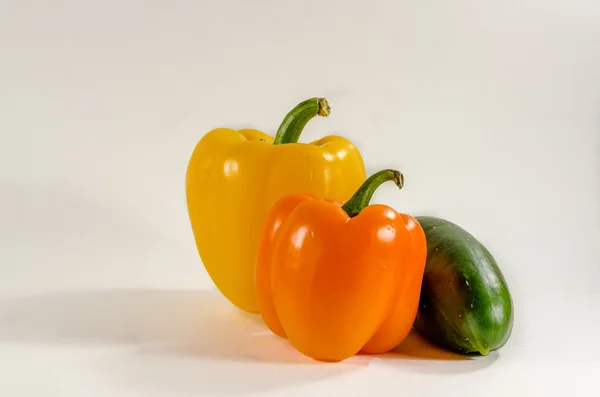 Taze salatalık, beyaz zemin üzerine sarı-turuncu biber
