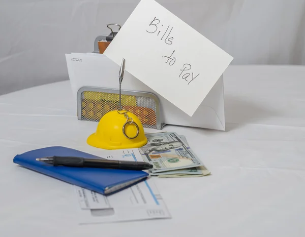 Bir çek defteri, kalem, nakit ve faturaları ödemek için