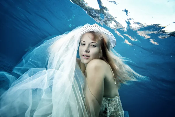 Chica en un vestido de novia bajo el agua — Foto de Stock