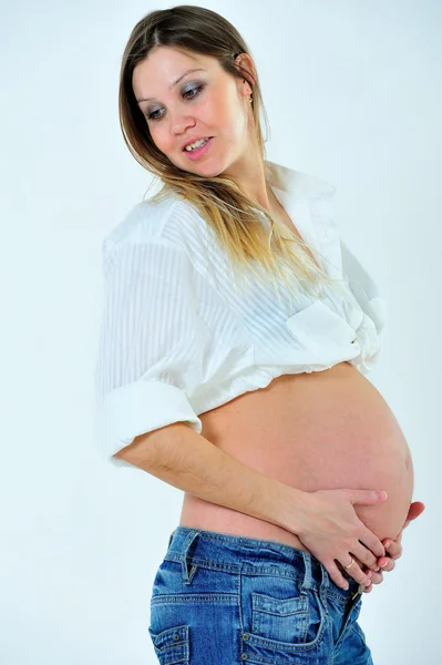 Dziewczyny w ciąży jest pozowanie z gołym brzuchem — Zdjęcie stockowe