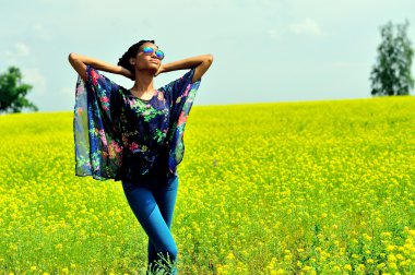 Afro-Amerikan kız giyiyor güneş gözlüğü, kot pantolon ve bir tunik, sta