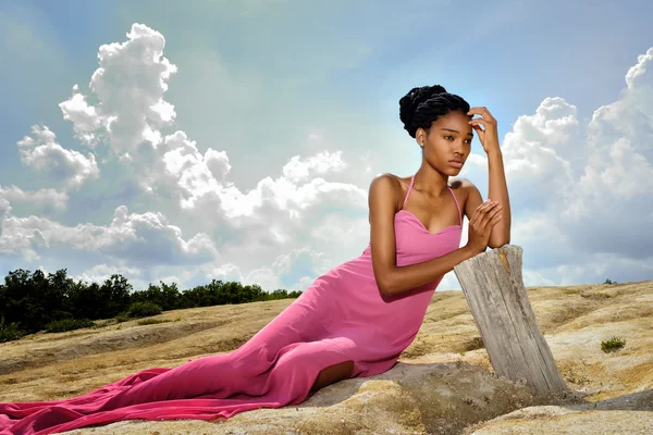 Menina afro-americana em vestido rosa deitado no chão no alto — Fotografia de Stock