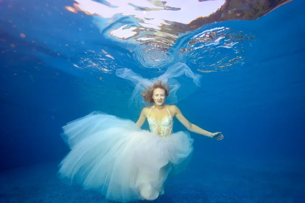 The bride dives cart in a white wedding dress against a blue background — Stock Photo, Image