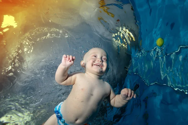 Bébé heureux nage et joue sous l'eau dans la piscine, se réjouit et rit avec plaisir. Gros plan. Portrait — Photo