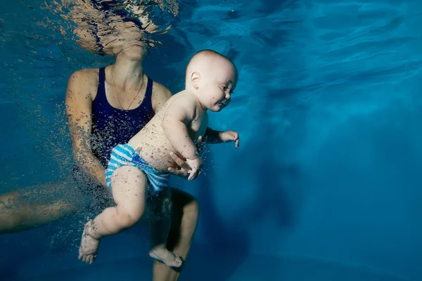 Maman aide le jeune garçon à nager sous l'eau dans la piscine. Gros plan. Portrait. Orientation horizontale — Photo