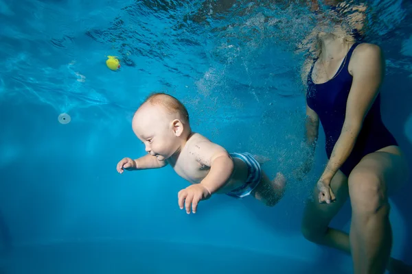Tout-petit nage avec sa mère sous l'eau dans la piscine. Gros plan. Portrait. Orientation horizontale — Photo