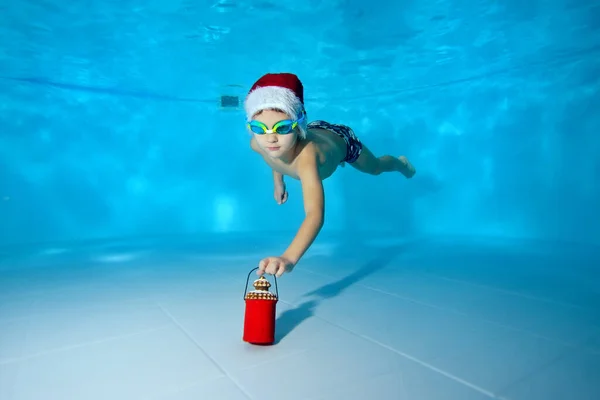 Cute Little Boy Red Santa Hat Swims Collects Christmas Toys — Stock Photo, Image