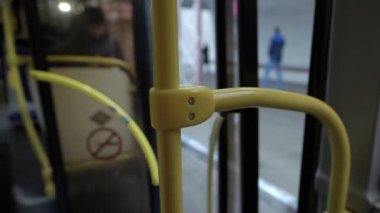 Otobüs kapıları kapanıyor ve duraktan uzaklaşıyor. Kuaförden görüntü. Kulübedeki korkuluklara yakın çekim. Arka plan bulanık. Kavram. 4K.