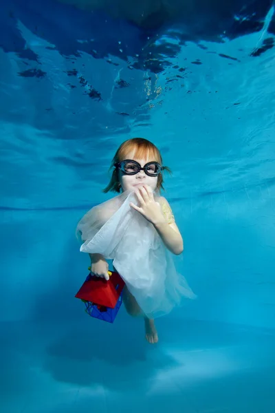 Retrato de una hermosa niña bajo el agua en la piscina. Ella sostiene una linterna. El bebé aprende a bucear. Clases de natación con un niño. Estilo de vida saludable. Orientación vertical — Foto de Stock