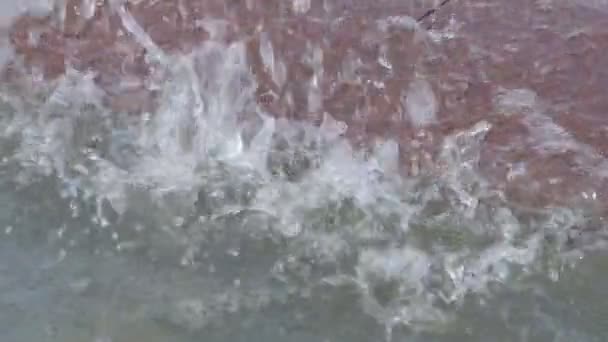 Langzame beweging van grote druppels koel water die vallen in de fontein van de stad op een grijze achtergrond op een zonnige zomerdag. Close-up — Stockvideo