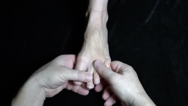Męski masażysta masuje kobietom gołe palce na czarnej sofie. Masaż terapeutyczny. Zbliżenie. Widok góry. Odbiór. 4K — Wideo stockowe