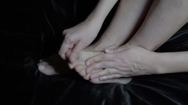 Eine Frau trägt auf und reibt eine heilende Creme auf ihre nackten Füße. Therapeutische Massage. Nahaufnahme. Kopierraum. 4K — Stockvideo