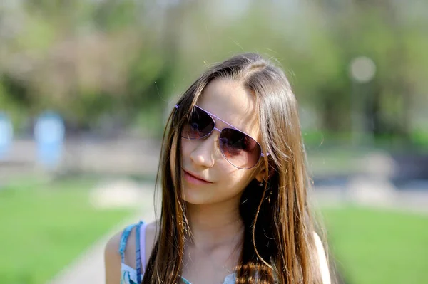 화창 한 여름날 공원에서 선글라스를 쓴 귀여운 10 대 소녀의 모습. 클로즈업. 개념. 수평 방향. — 스톡 사진
