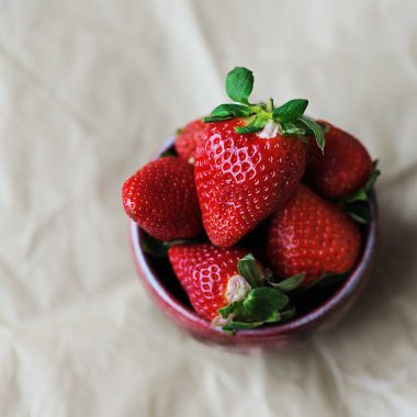 Kraft kağıt üzerinde bir seramik bardak çilek. Üstten görünüm, metin için yer.