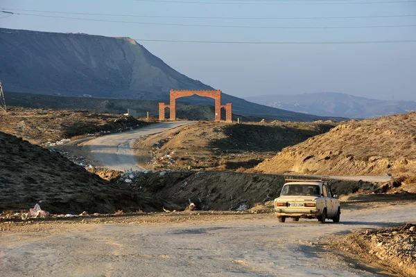 Arco sobre estrada rural na frente de colinas no Azerbaijão — Fotografia de Stock