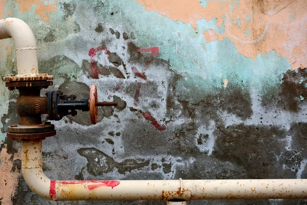 Vinklade metallrör med ventil mot färgglada peeling vägg i Baku, Azerbajdzjan — Stockfoto