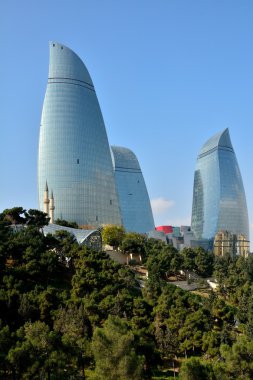 Bakü, Azerbaycan, başkenti ön planda ağaçları ile güneş alev kuleleri bakarak