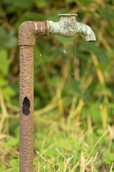 Antiguo tubo oxidado con agujero y grifo roto —  Fotos de Stock