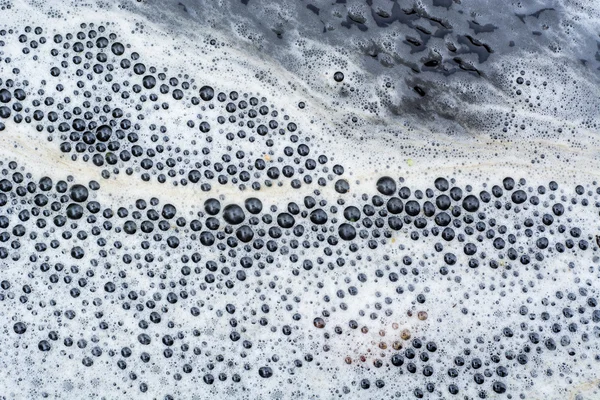 Szumowiny organicznych tworzących linii piany na powierzchni wody rzecznej — Zdjęcie stockowe