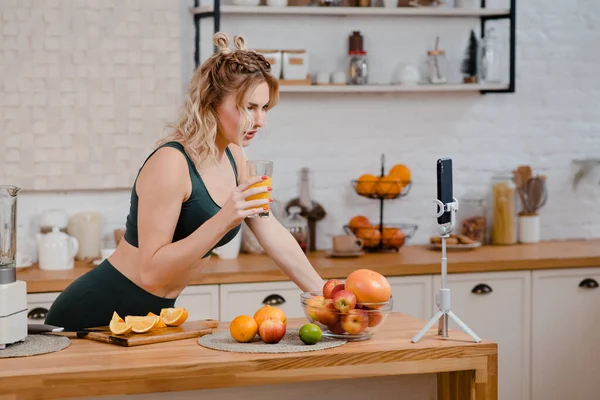 Fitness blogger recording video on mobile about healthy diet