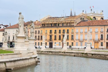 Padova, İtalya - 14 Nisan 2025: İtalya 'nın Padua kentindeki kanallar boyunca uzanan heykeller, liman boyunca uzanan tarihi mimari ve renkli binaları vurguluyor.