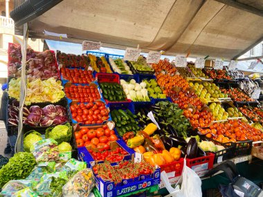 Padova, İtalya - 19 Ocak 2025: Çeşitli domates, marul, patlıcan ve diğer sebze çeşitleri de dahil olmak üzere çeşitli taze ürünler sergilenmektedir. Kalabalık bir gıda pazarından tipik bir sahne..