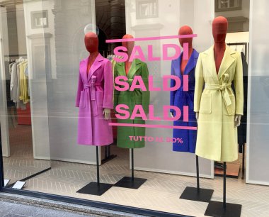 Parlak gözlüklü kaşmir paltolu bir dükkan penceresi. 