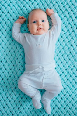 Mavi gözlü, sevimli, yeni doğmuş erkek bebek. İçeriden çekilmiş bir portresi var. Beyaz pijamayla turkuaz yün ekose üzerinde tombul yanaklı şirin bir çocuk. Komik hemşire çocuk duyguları..