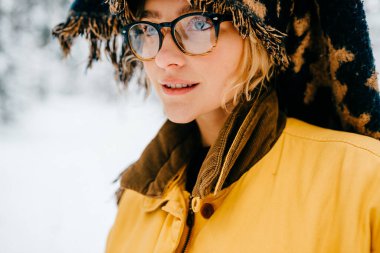 Gözlüklü ve başını örten fular takan komik genç hippi kızın portresini kapat. 