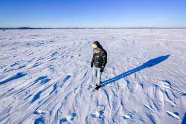 Yalnız stil sahibi adam kar tarlasında poz veriyor 