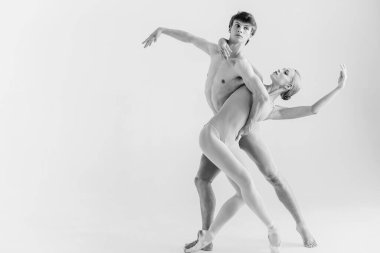 Beyaz stüdyo arka planında poz veren modern balerinler.