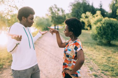 Açık havada ilişki hakkında konuşan koyu tenli bir çift.
