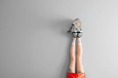 Güzel kadın bacakları beyaz örgü çoraplar içinde şık siyah, yüksek topuklu deri sandaletler giyiyorlar. Gri arka planda duran Rus mavi kedisiyle şık ayakkabılı kadınların uzun bacakları